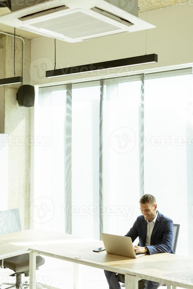uomo d'affari seduta e Lavorando nel computer portatili a il ufficio foto