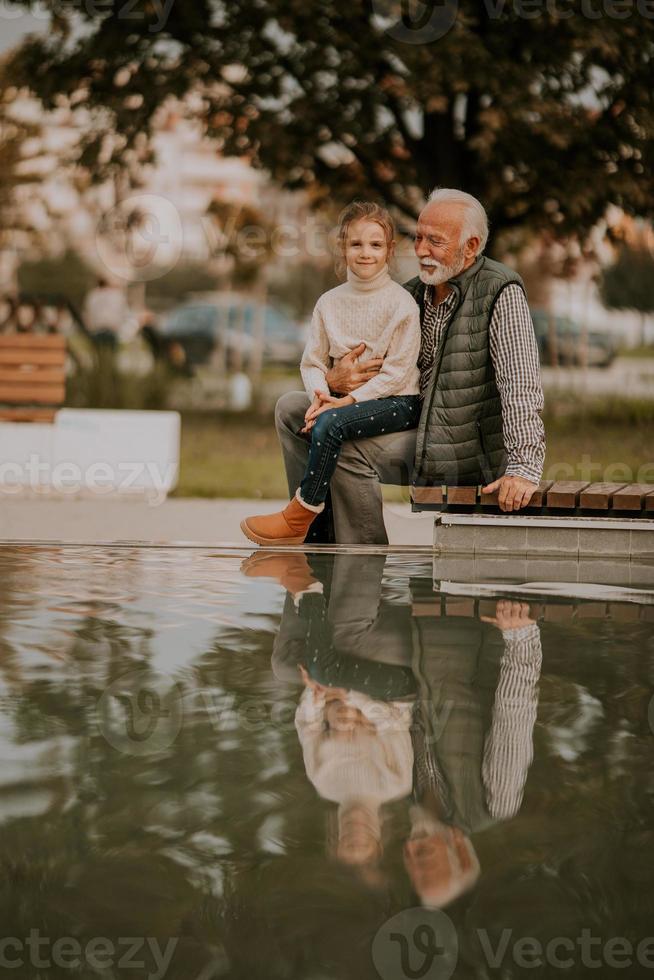 nonno la spesa tempo con il suo nipotina di piccolo acqua piscina nel parco su autunno giorno foto