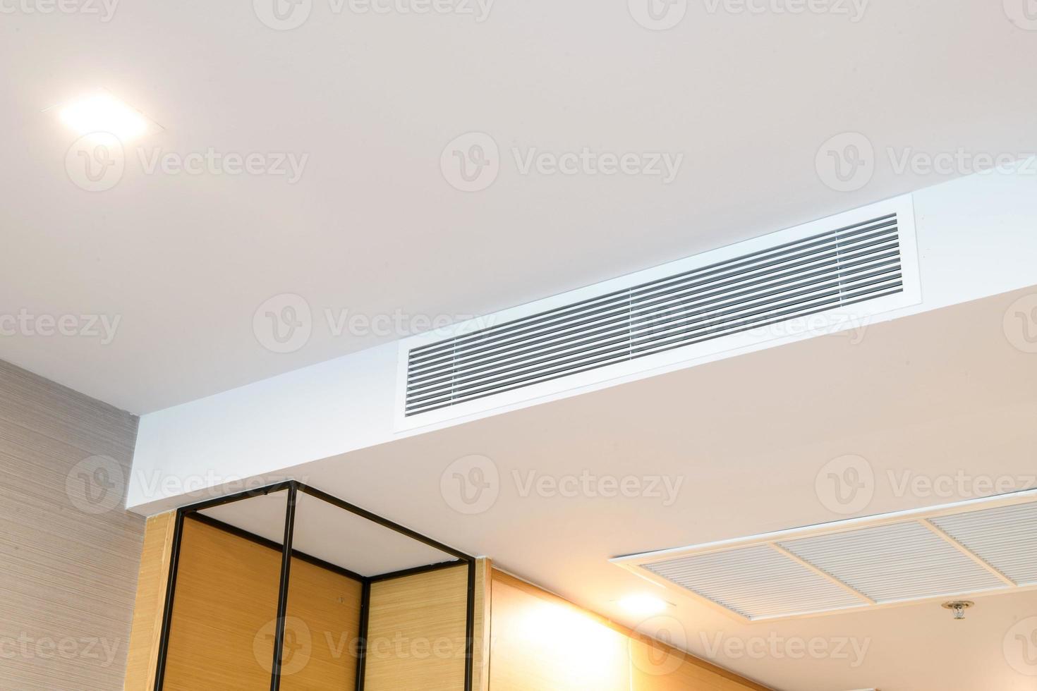 soffitto montato cassetta genere aria condizionatore e moderno lampada leggero su bianca soffitto. condotto aria condizionatore per casa o ufficio foto