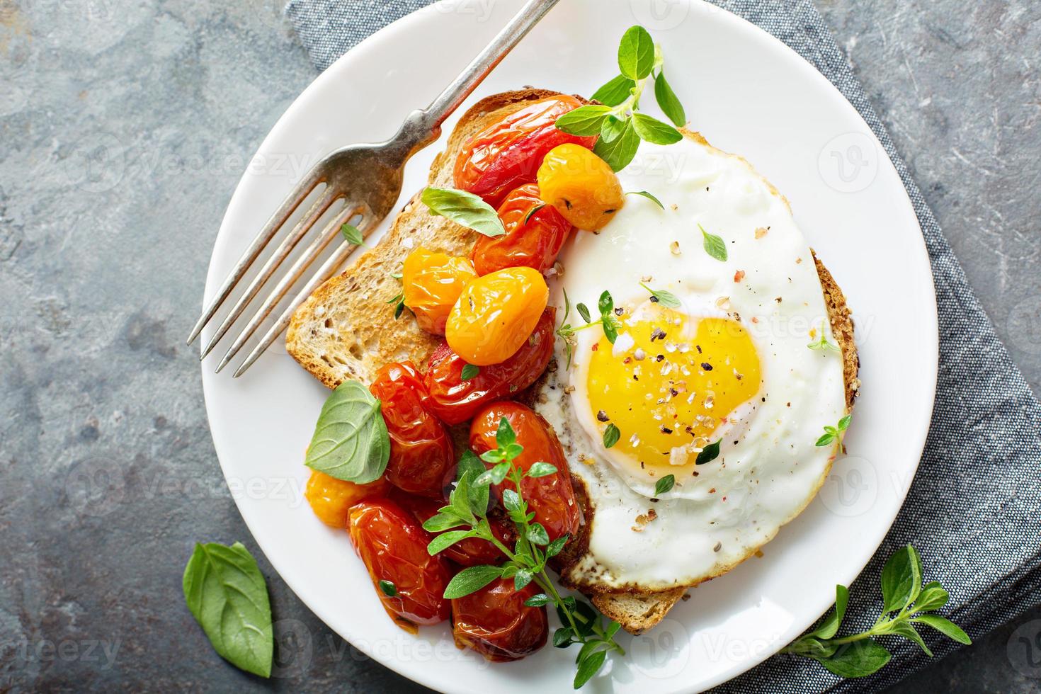 multicereali crostini con fritte uovo e arrostito pomodori foto