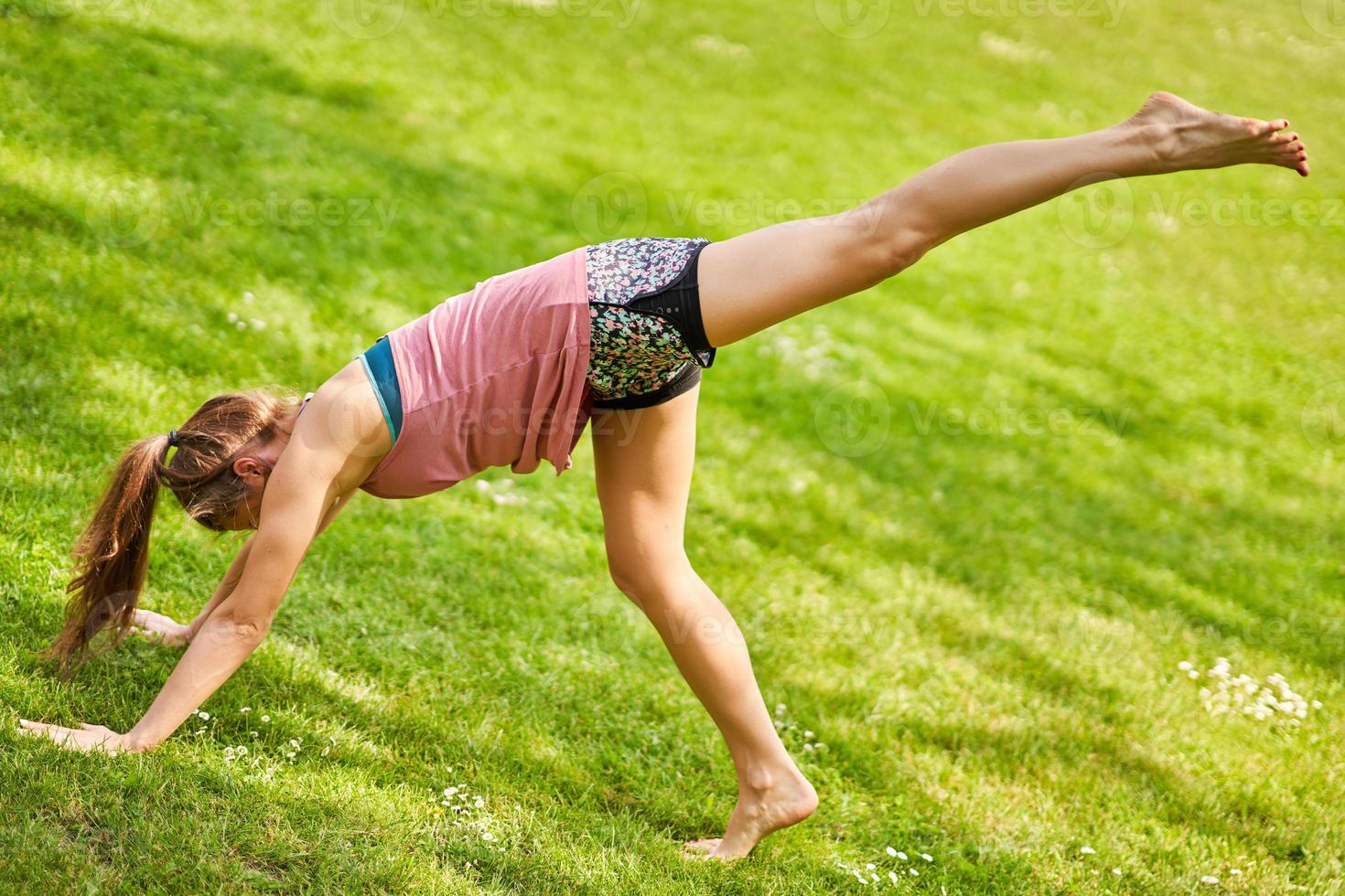 giovane donna fare yoga nel parco foto