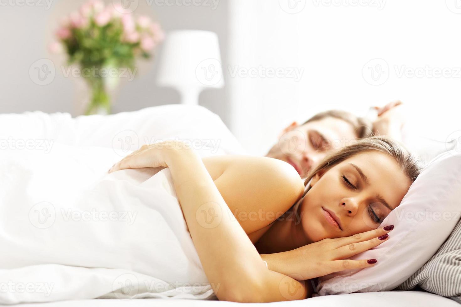 giovane coppia che dorme nel letto foto