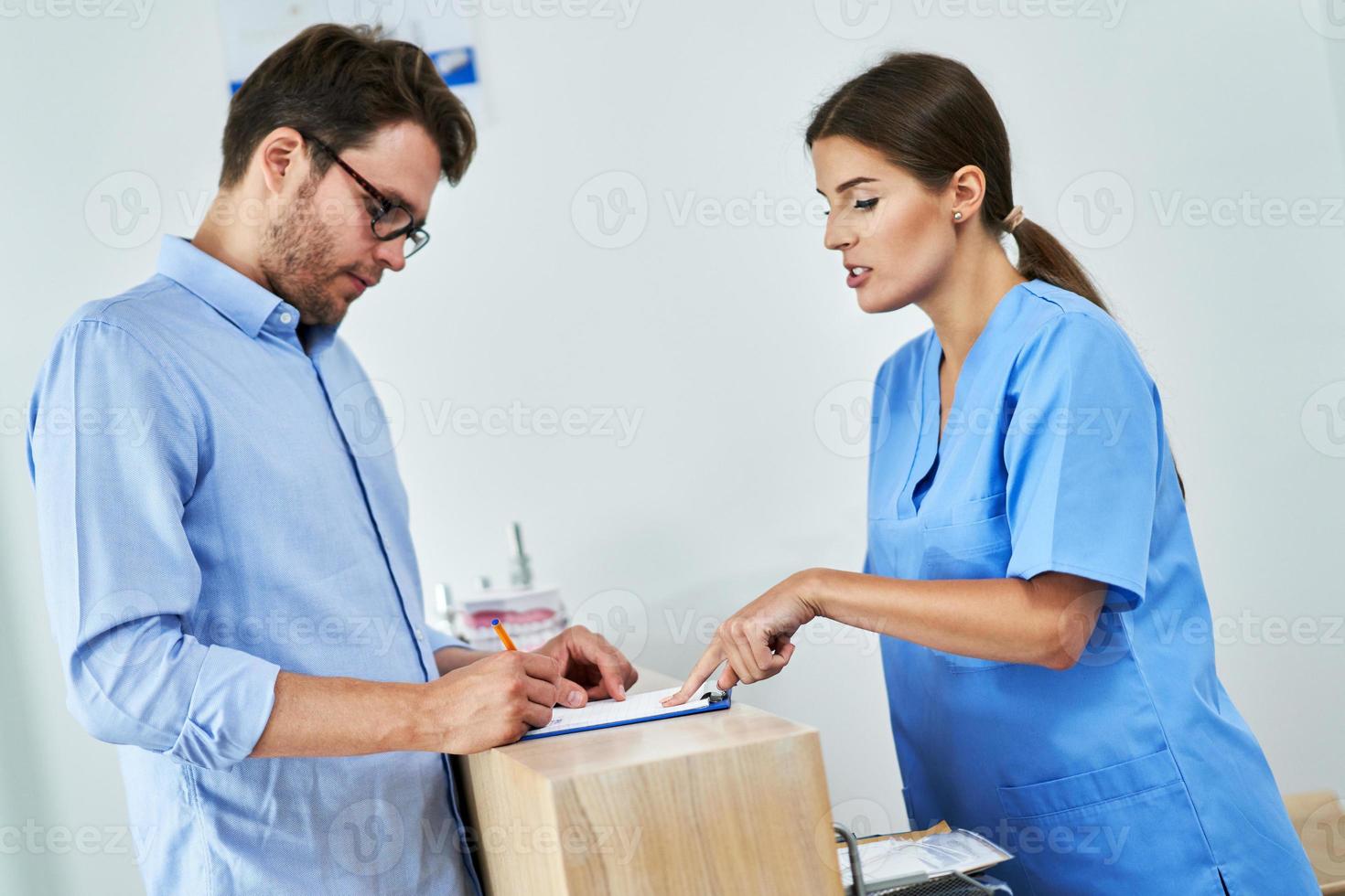 paziente firma documenti nel dentale clinica foto