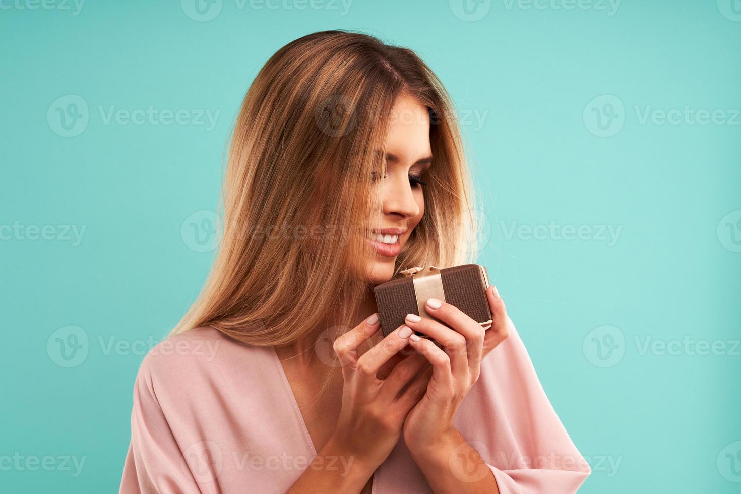 bellissimo adulto donna in posa al di sopra di blu sfondo con presente foto