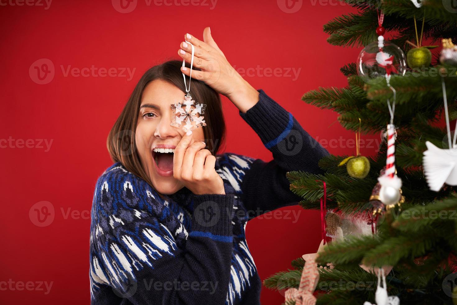 adulto donna decorazione Natale albero al di sopra di rosso sfondo foto