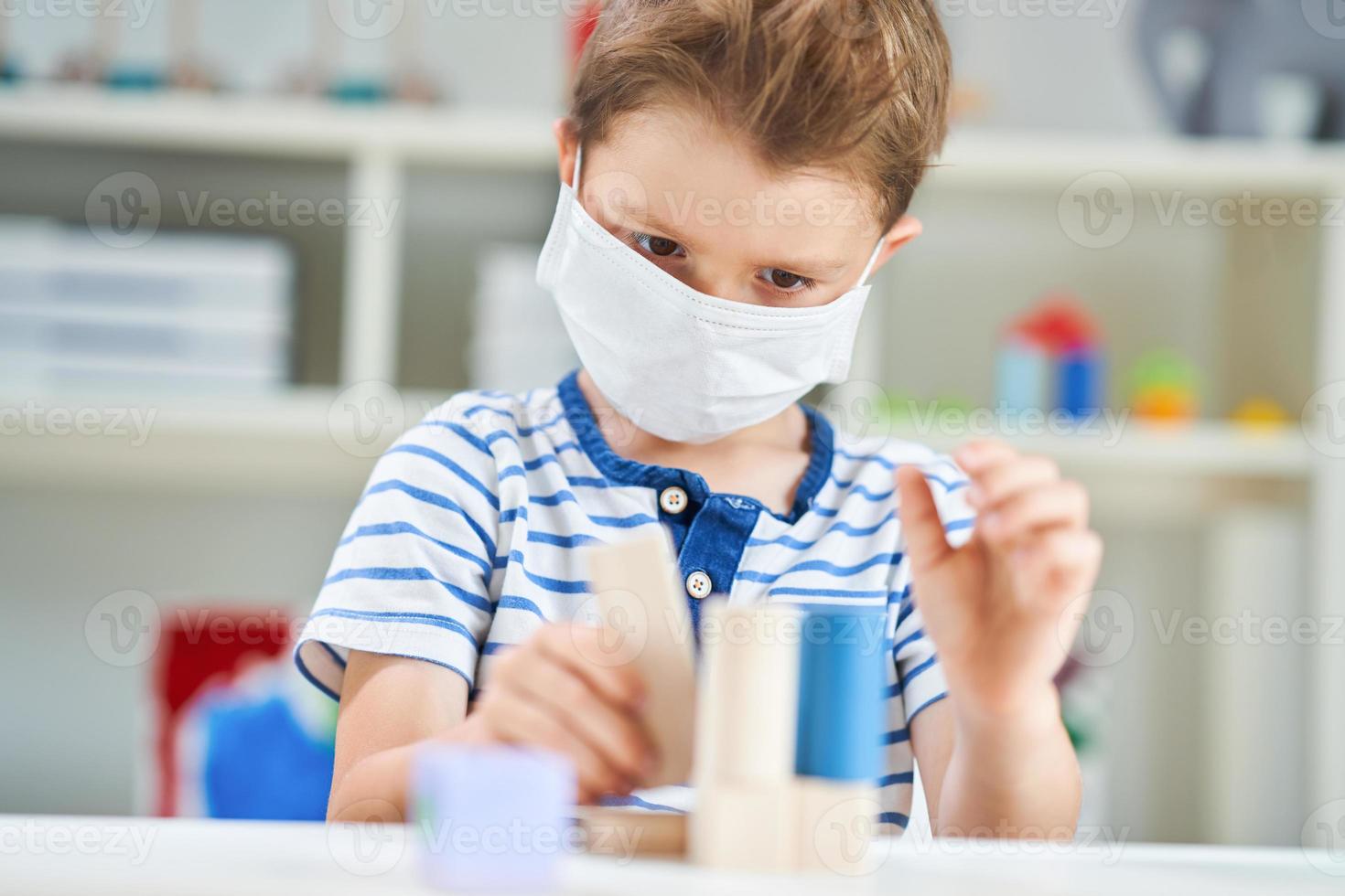 adorabile poco ragazzo nel scuola materna con maschera su dovuto per coronavirus pandemia foto