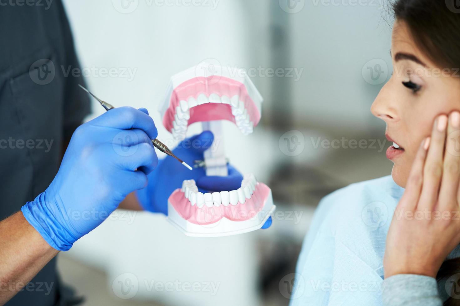 maschio dentista mostrando mascella per donna nel dentista ufficio foto