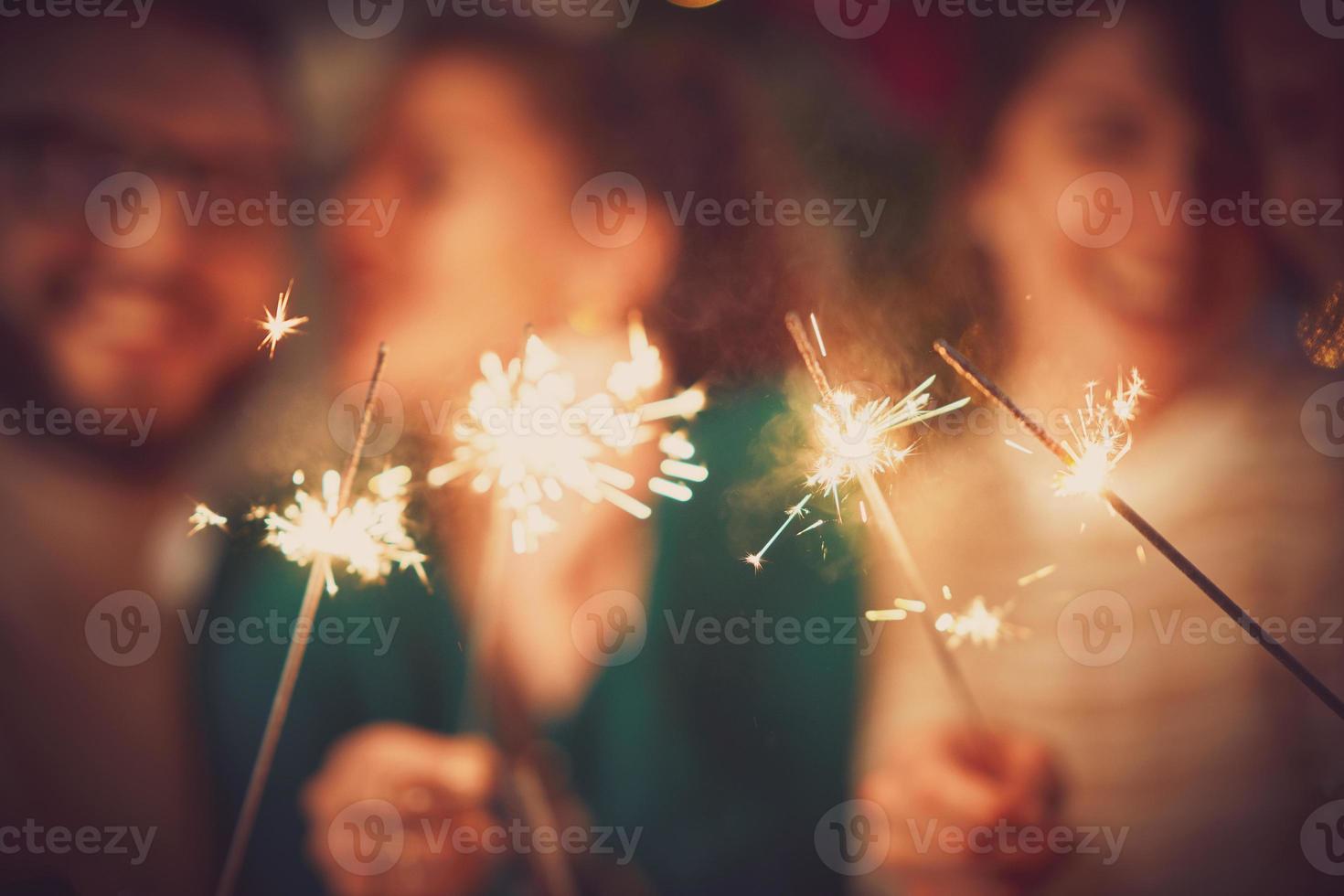 gruppo di amici con sparklers festeggiare Natale a casa foto