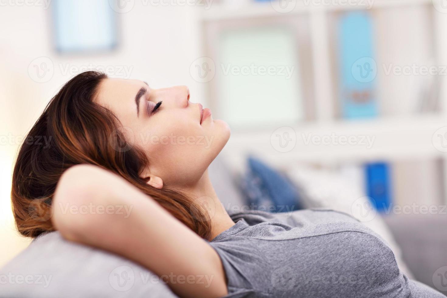 rilassato giovane donna godendo riposo su confortevole divano foto