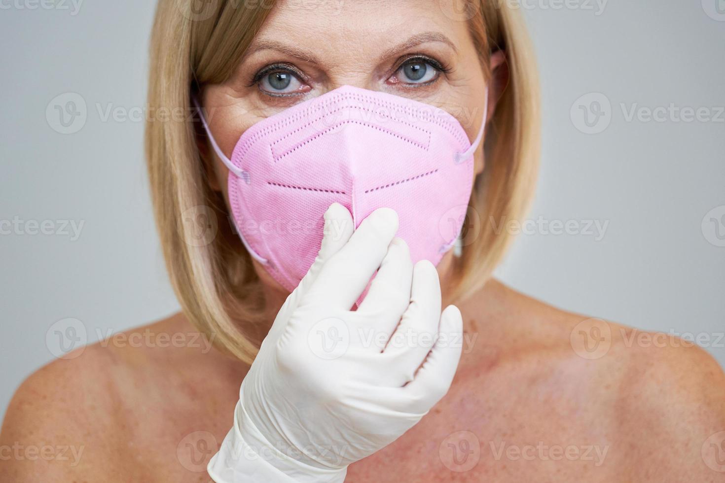 anziano donna in posa al di sopra di grigio sfondo foto