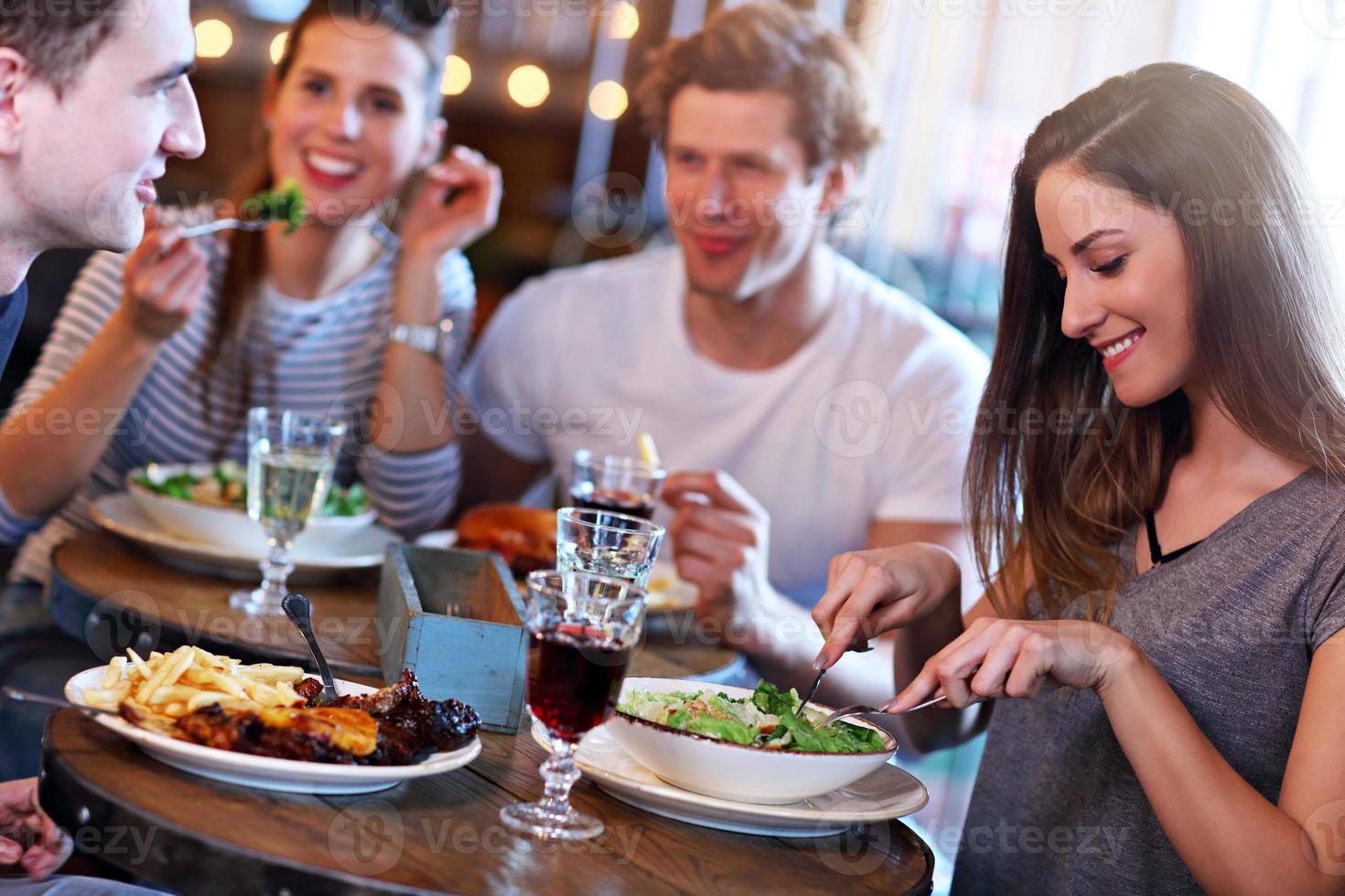 gruppo di amici godendo pasto nel ristorante foto