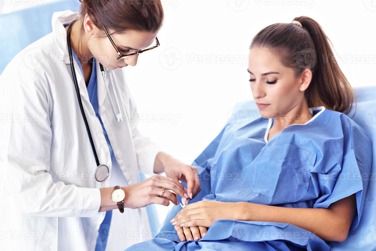 femmina medico assunzione cura di paziente nel ospedale foto
