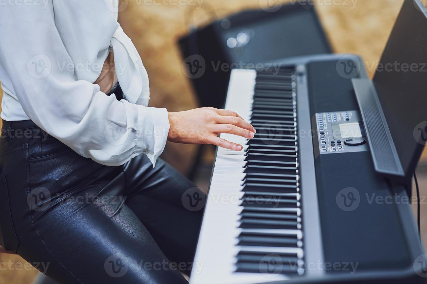 caucasico donna giocando su tastiera con gruppo musicale foto