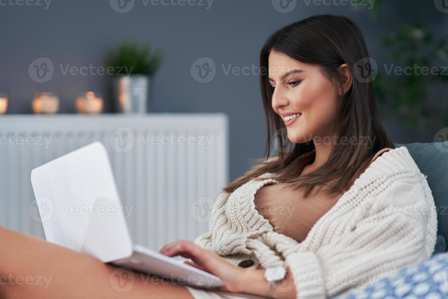 giovane donna utilizzando computer a casa foto