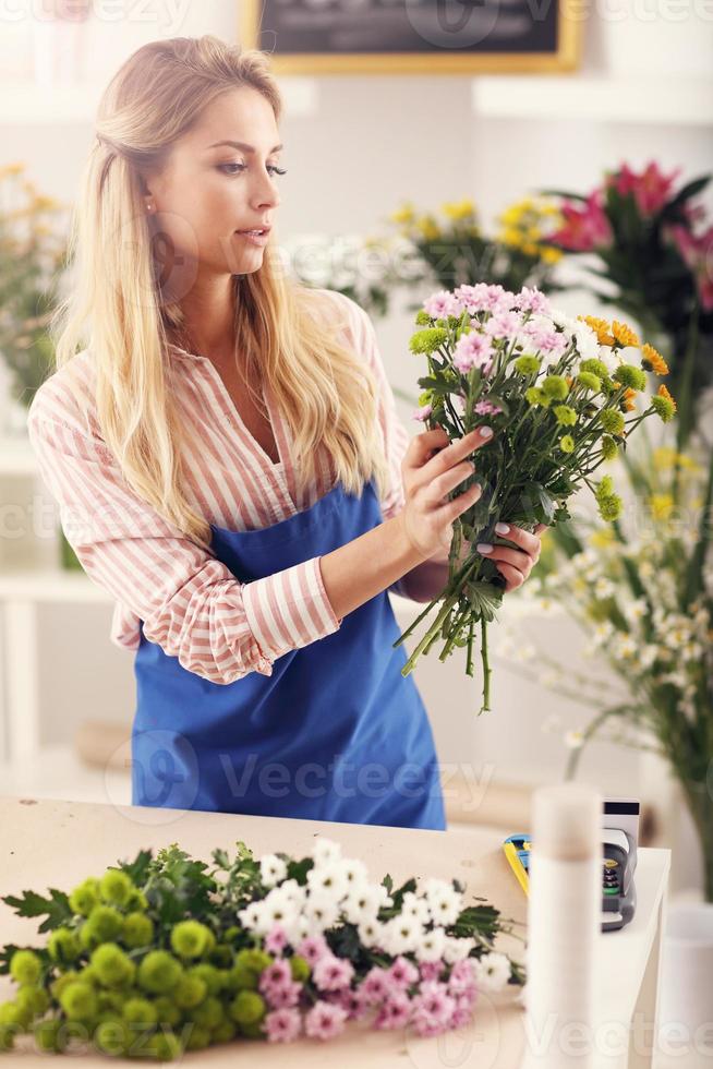 femmina fioraio Lavorando nel fiore negozio foto