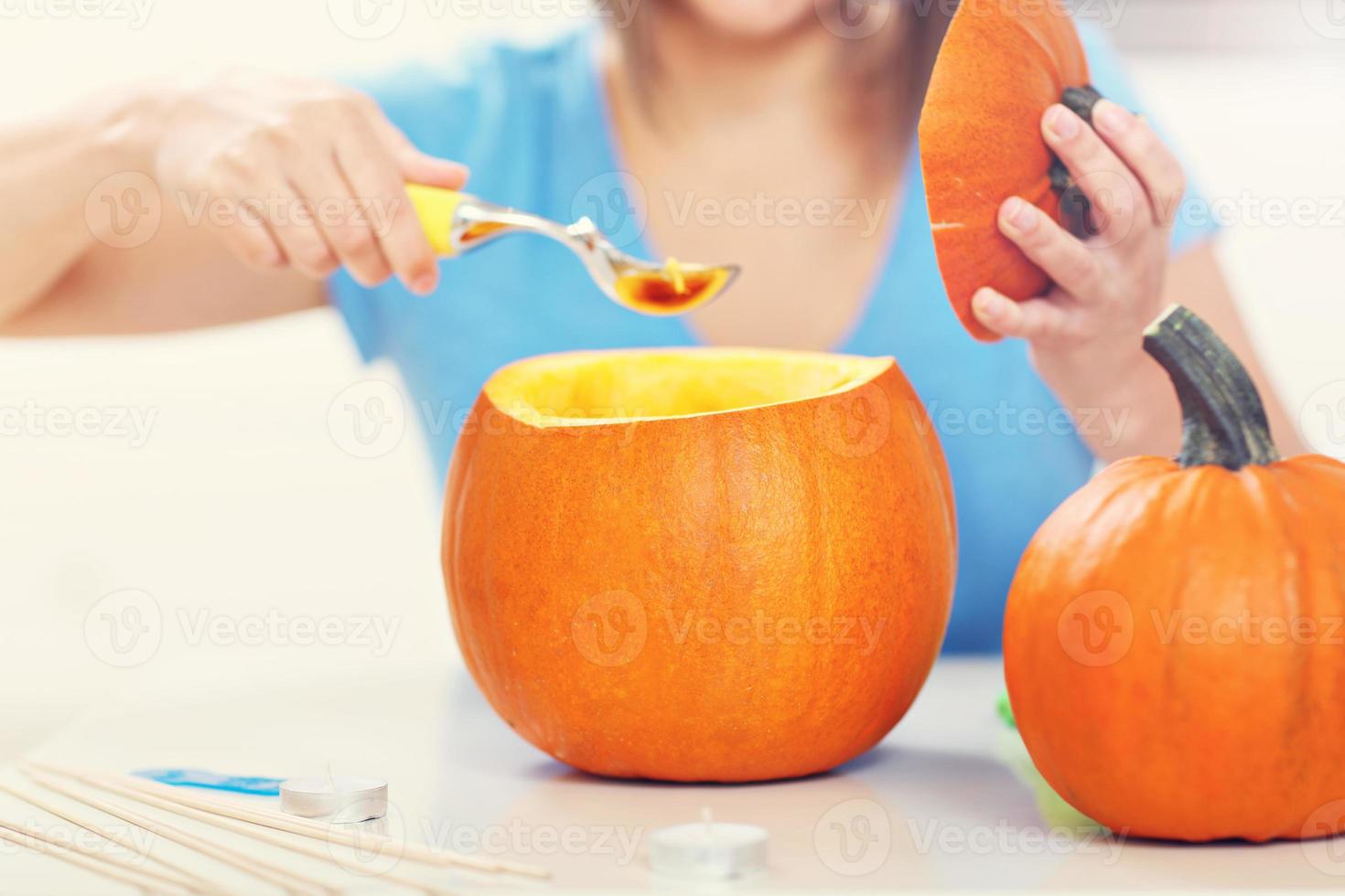 giovane donna fabbricazione jack-o-lanterna nel il cucina foto