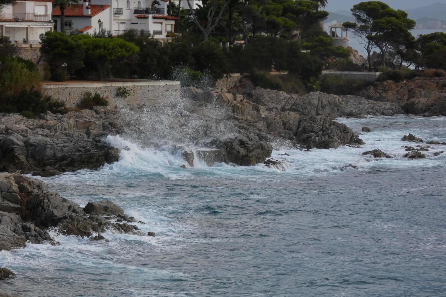 mare raggiungendo il rocce la creazione di spruzzi di schiuma foto