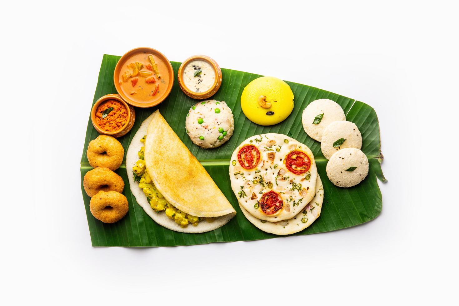 Sud indiano masala dosa, uttapam, idli vada sambar, semolino hawa, upma servito al di sopra di Banana foglia foto