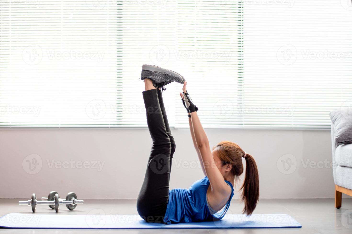 asiatico donne esercizio per rafforzare il addominale muscoli a casa. foto