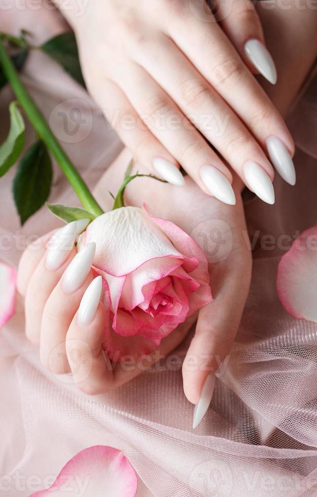 mani di un' giovane donna con bianca manicure su Chiodi foto