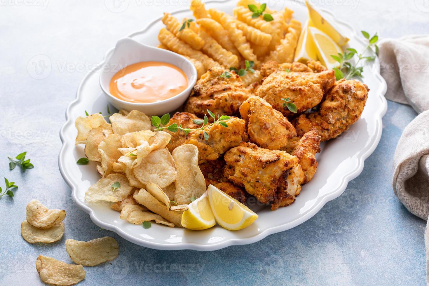 pesce e patatine fritte su un' servendo piatto con immersione salsa foto