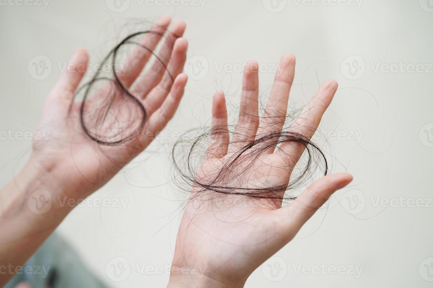 la donna asiatica ha problemi con la caduta dei capelli lunghi attaccata in mano. foto