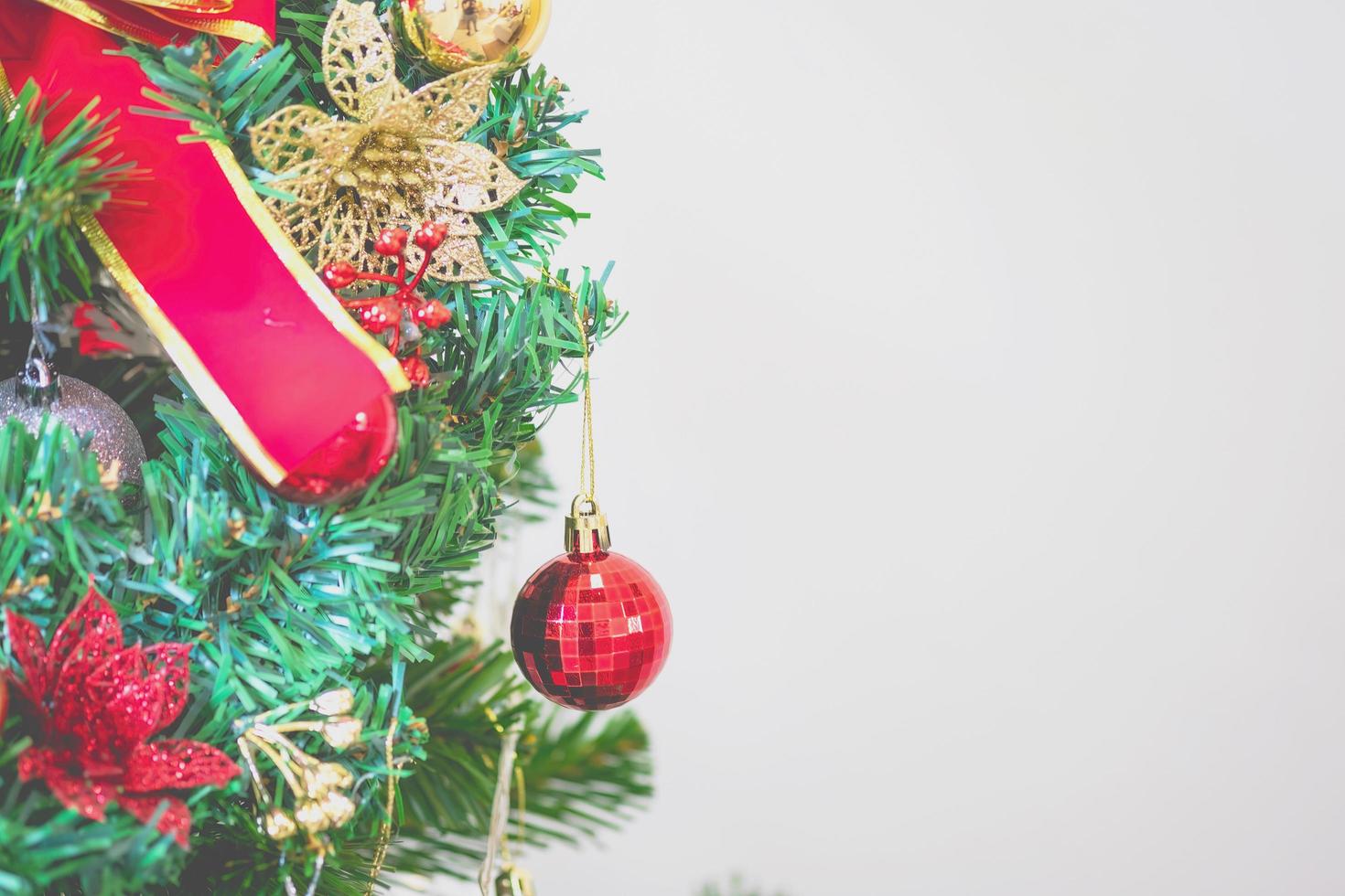 avvicinamento di un' meravigliosamente decorato Natale albero dentro un' casa per il imminente Natale vigilia vacanza con un' bianca sfondo. foto