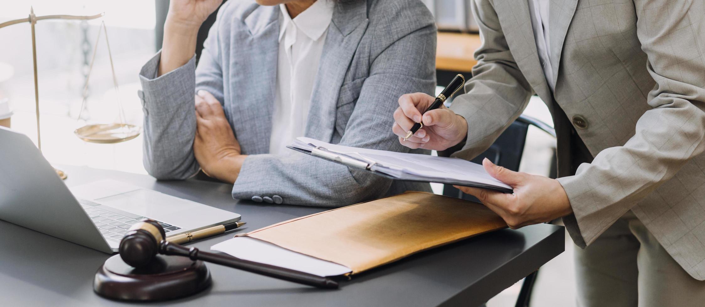 concetto di giustizia e diritto. giudice maschio in un'aula di tribunale su tavolo di legno e consigliere o avvocato maschio che lavora in ufficio. diritto legale, consulenza e concetto di giustizia. foto