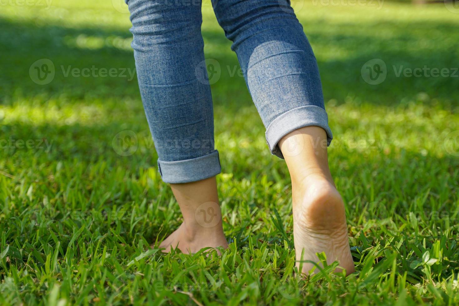 asiatico donna a piedi a piedi nudi su il erba per sentire il natura contribuisce per fabbricazione persone sentire a pace avere Di Più mentale stabilità. morbido e selettivo messa a fuoco. foto