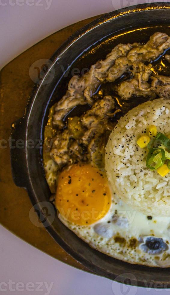 prima colazione con Riso, fritte uovo e carne o Manzo con contorno Mais e Porro vicino su caldo piatto isolato su bianca sfondo foto