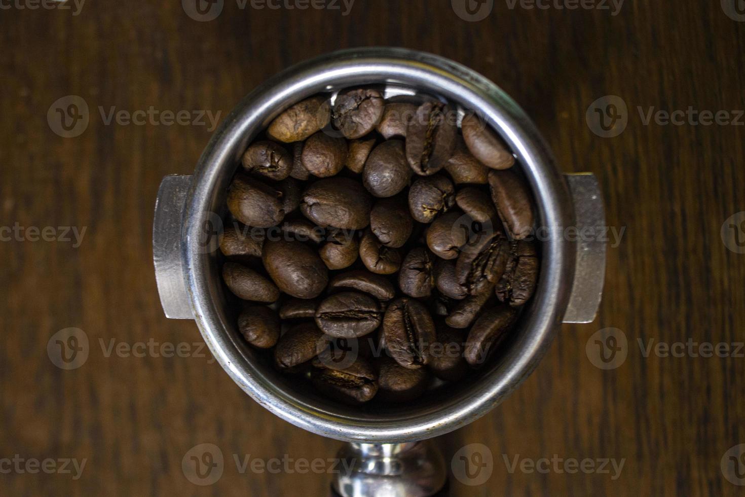 Porta filtro con terra caffè e caffè fagiolo su tavolo foto