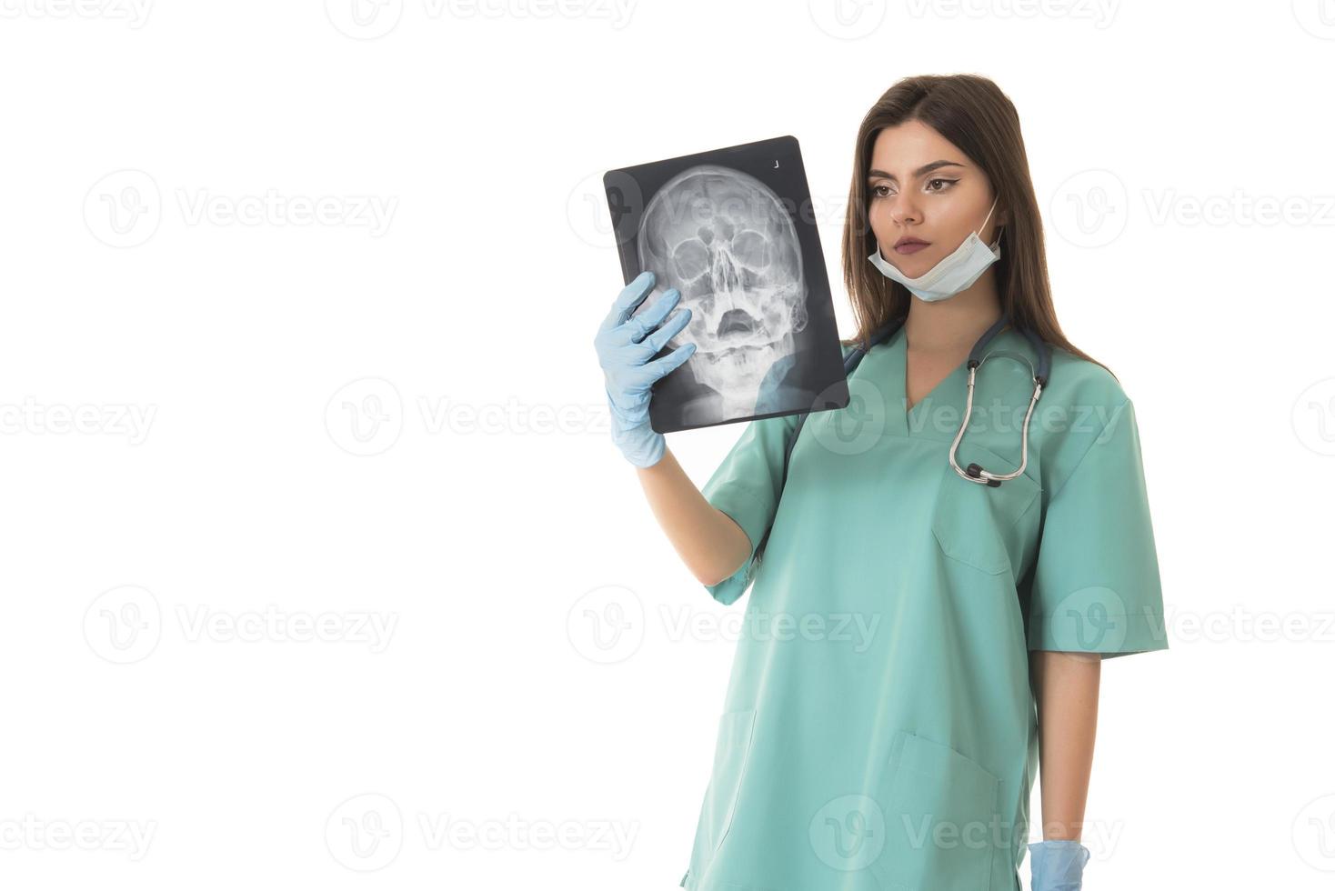 giovane femmina medico guardare a il raggi X immagine. isolato su bianca foto
