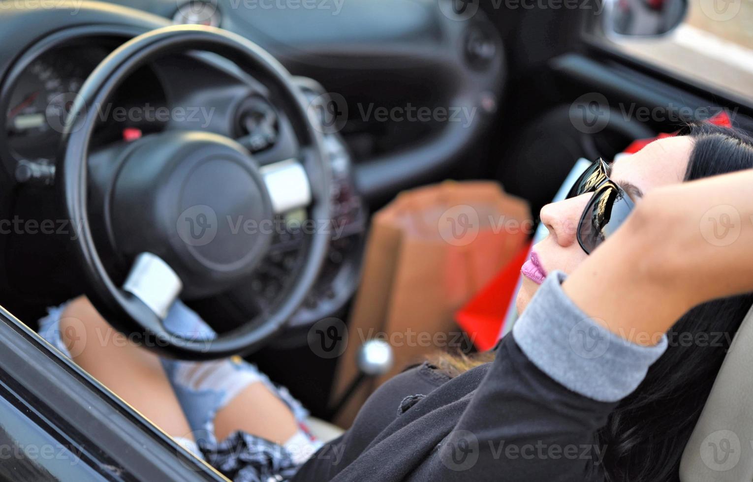 contento bellissimo donna guida un' gli sport auto nel il città foto