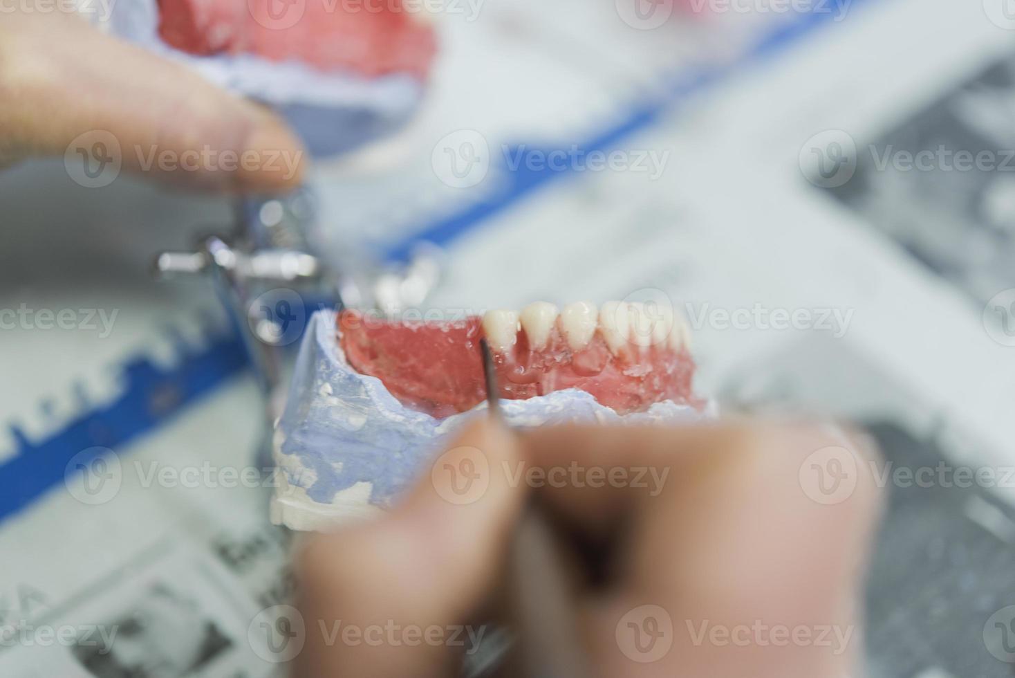 dentale protesi, dentiere, protesi opera. protesi mani mentre Lavorando su il dentiera, falso denti, un' studia e un' tavolo con dentale utensili foto