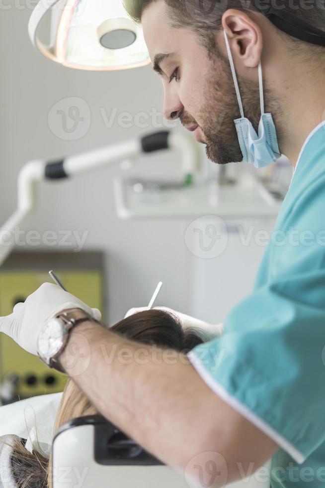 dentista curare del paziente denti Riempimento cavità. dentista Lavorando con professionale attrezzatura nel clinica. foto