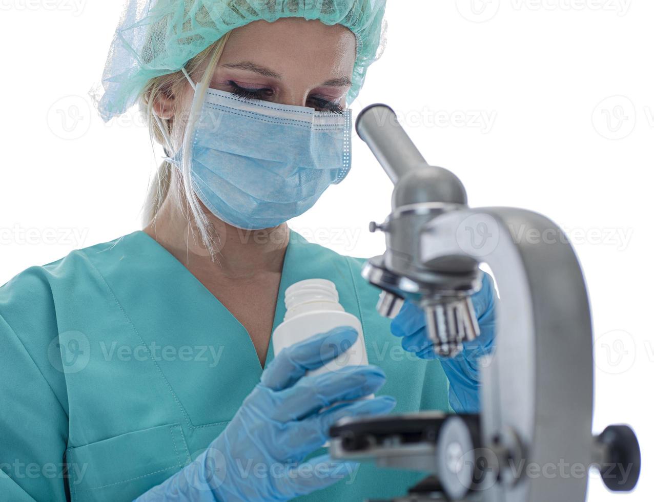 scienziato nel blu medico guanti e uniforme apprendimento covid-19 campioni con microscopio nel laboratorio. foto