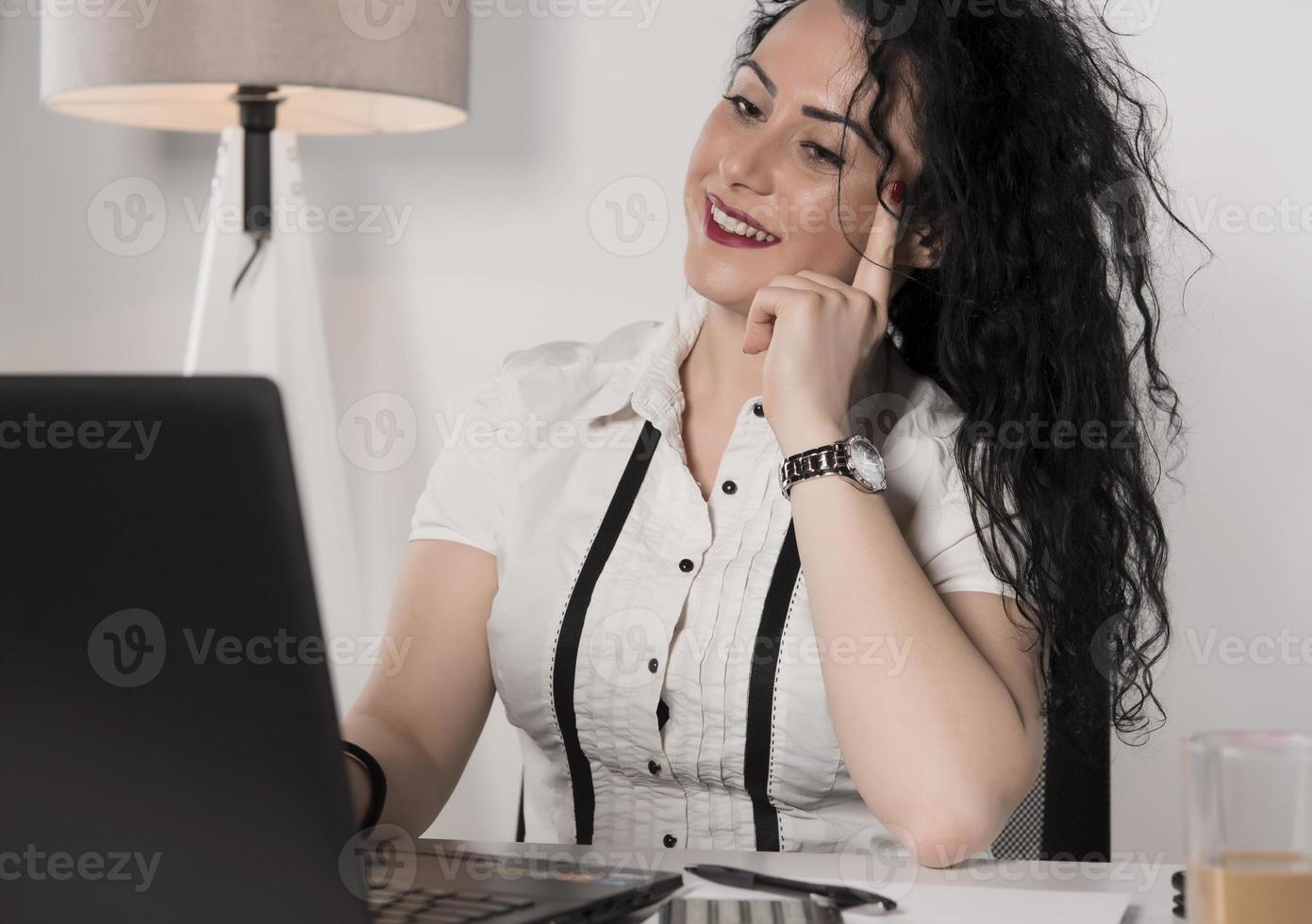 bellissimo attività commerciale donna seduta nel sua ufficio e parlando su il cellulare. attività commerciale concetto foto