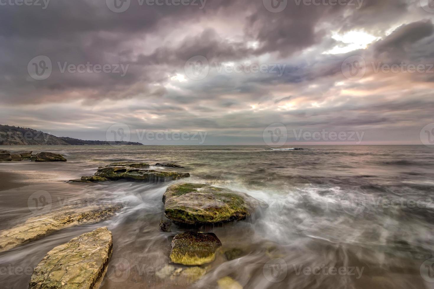 sorprendente lungo esposizione paesaggio marino con movimento sfocatura e fluente onde a scogliere. foto