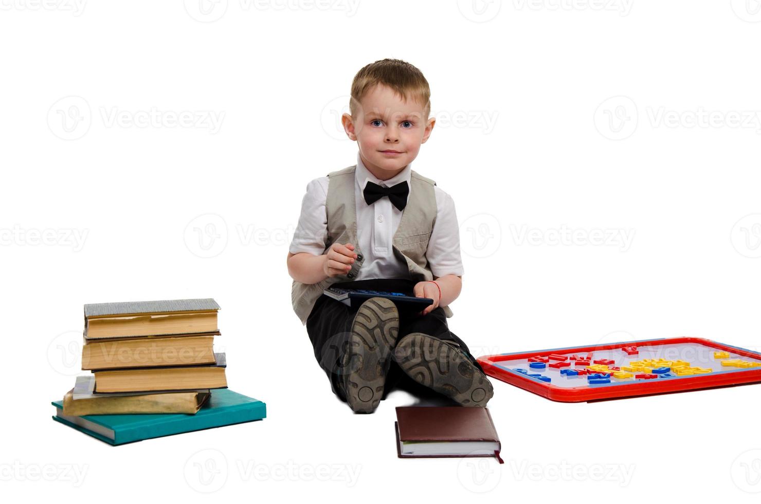 allegro poco ragazzo nel elegante Abiti studiando foto