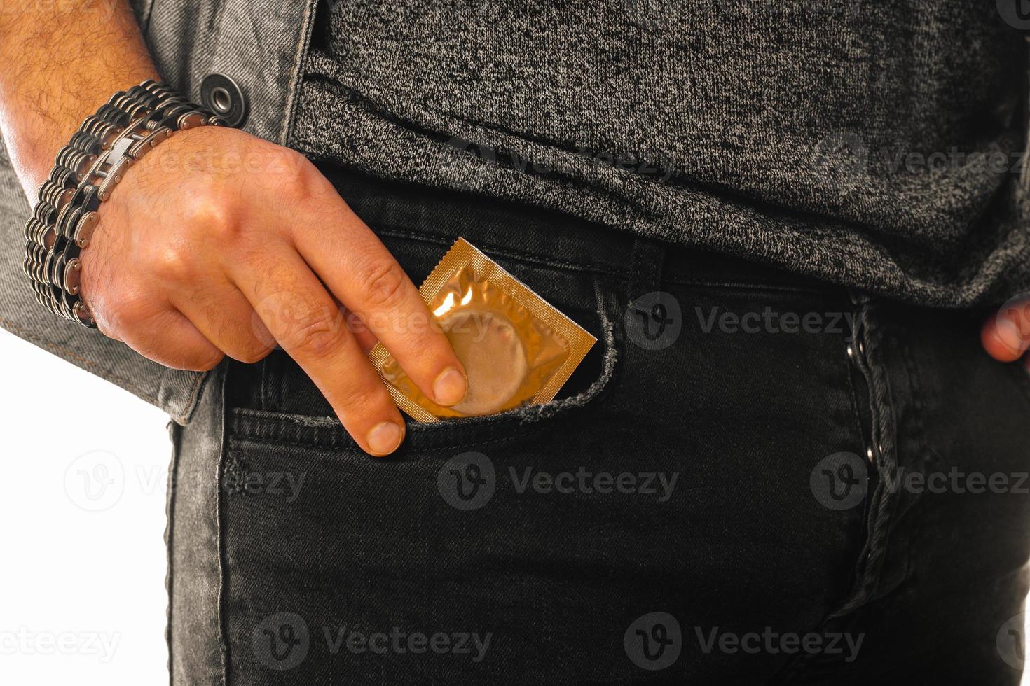uomo prende un' d'oro preservativo su di il suo tasca foto