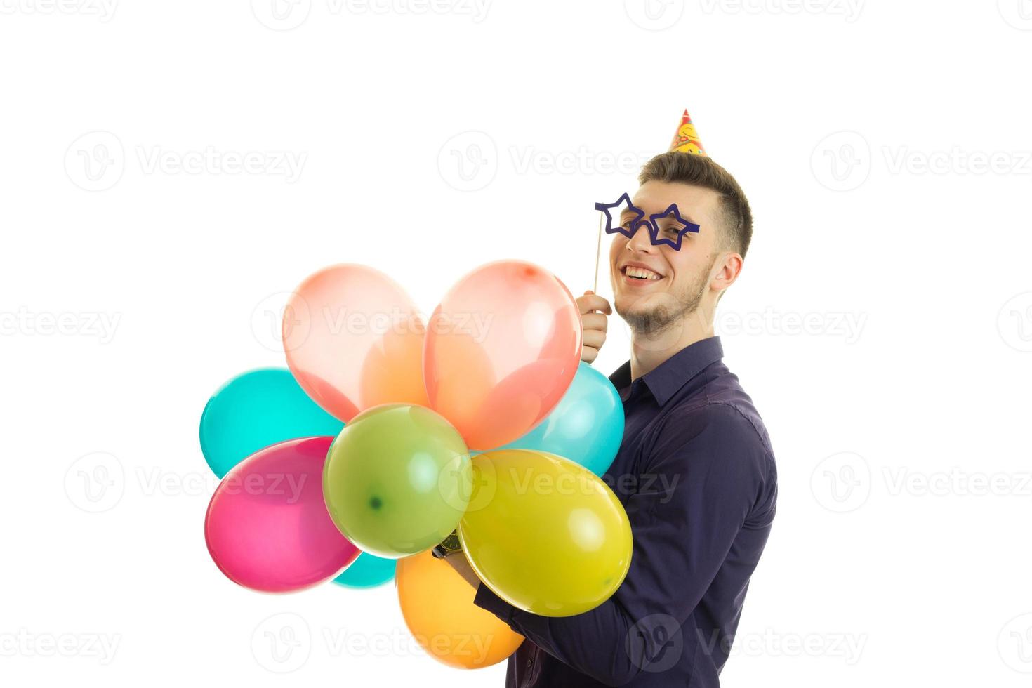 contento giovane uomo nel carta bicchieri e palloncini nel il suo mani sorridente foto