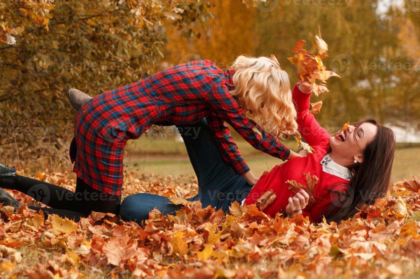 Due bellissimo ragazze amici avendo divertimento nel autunno parco foto