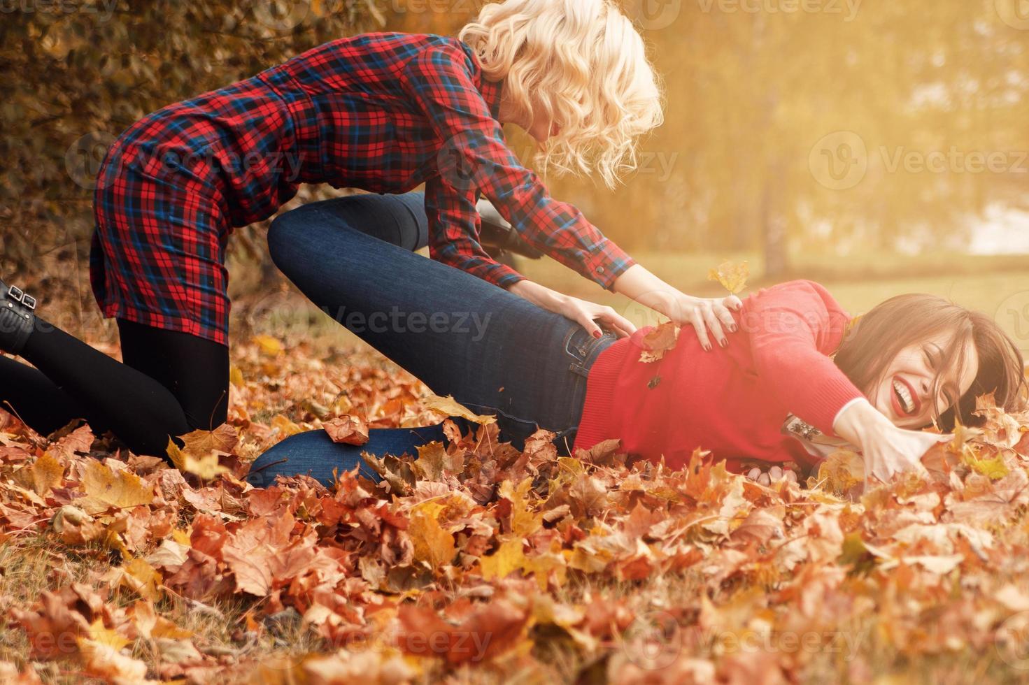 Due bellissimo ragazze amici avendo divertimento nel autunno parco foto