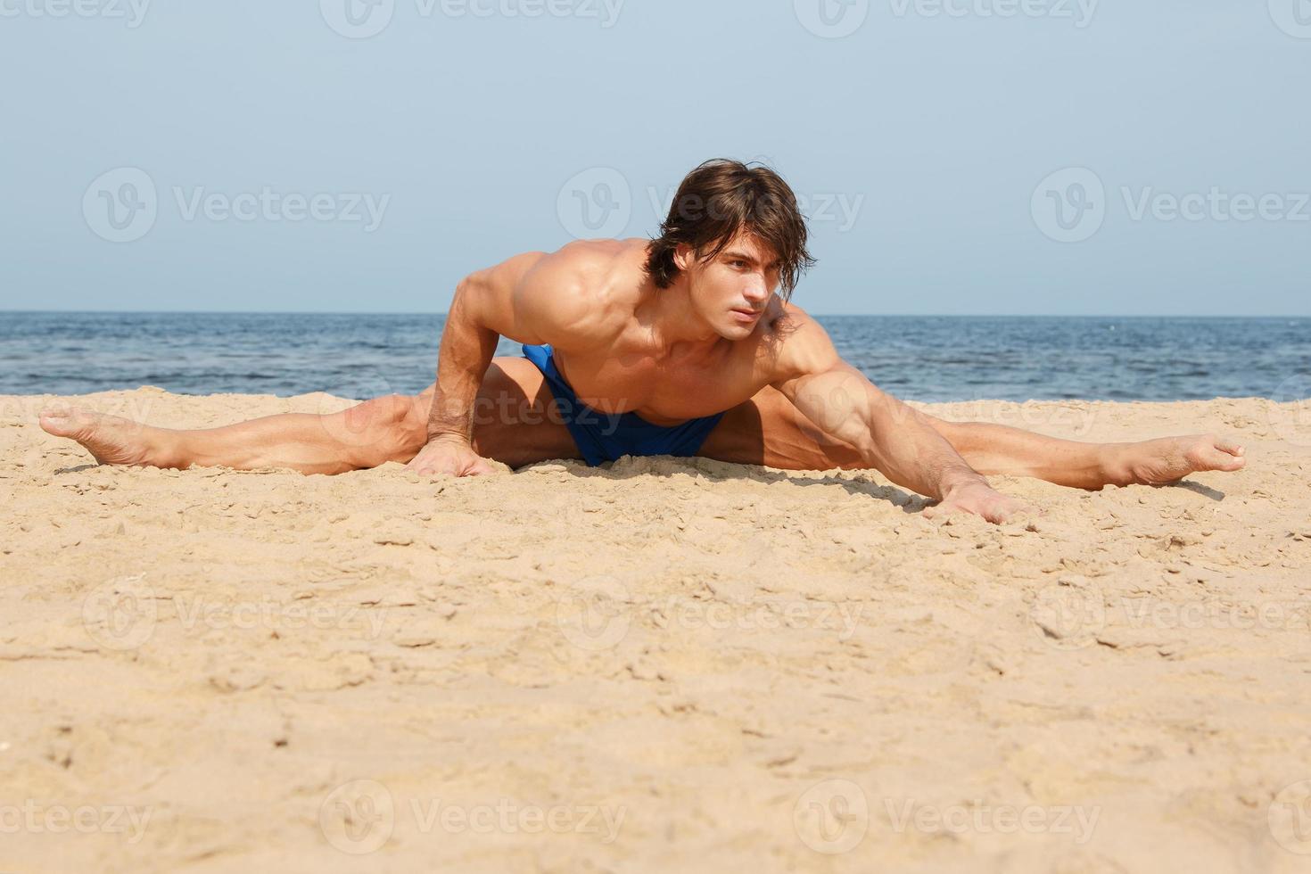 muscolare uomo durante il suo allenarsi su il spiaggia foto