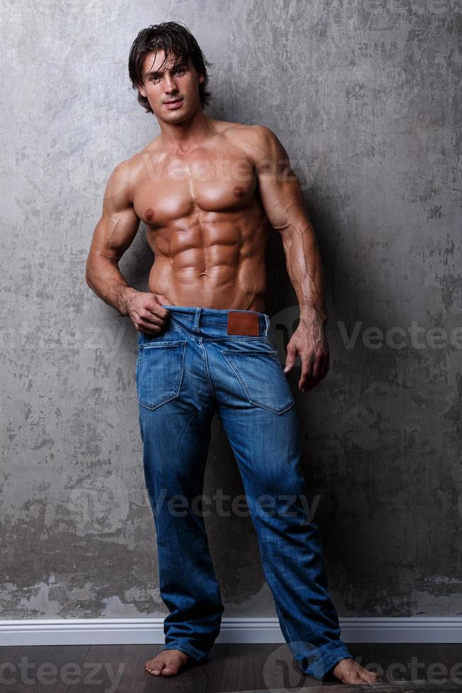 ritratto di bello muscolo uomo indossare blu jeans foto