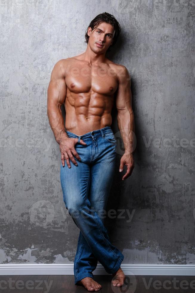 ritratto di bello muscolo uomo indossare blu jeans foto