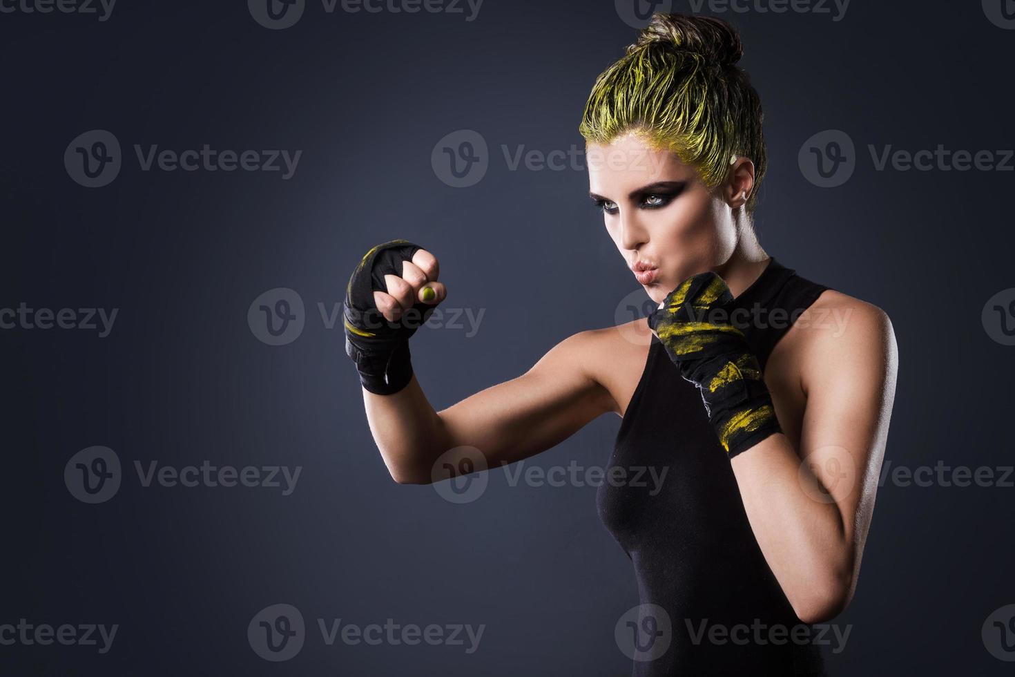 donna mma combattente con giallo capelli nel studio foto