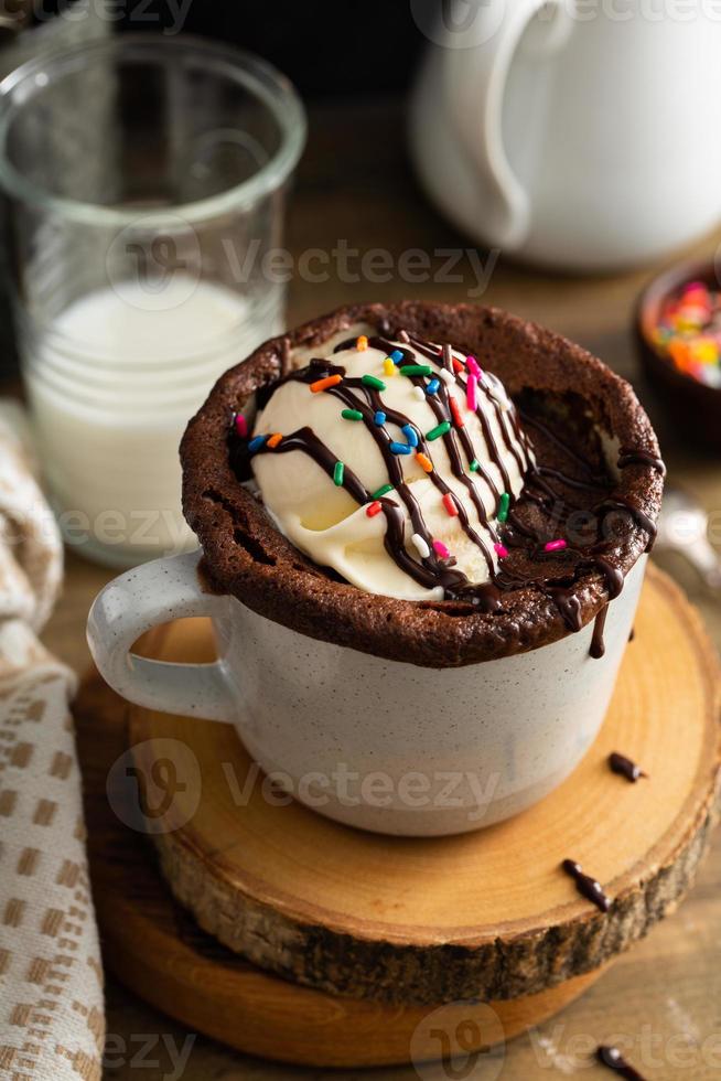 cioccolato torta nel un' boccale con ghiaccio crema e spruzzatori foto