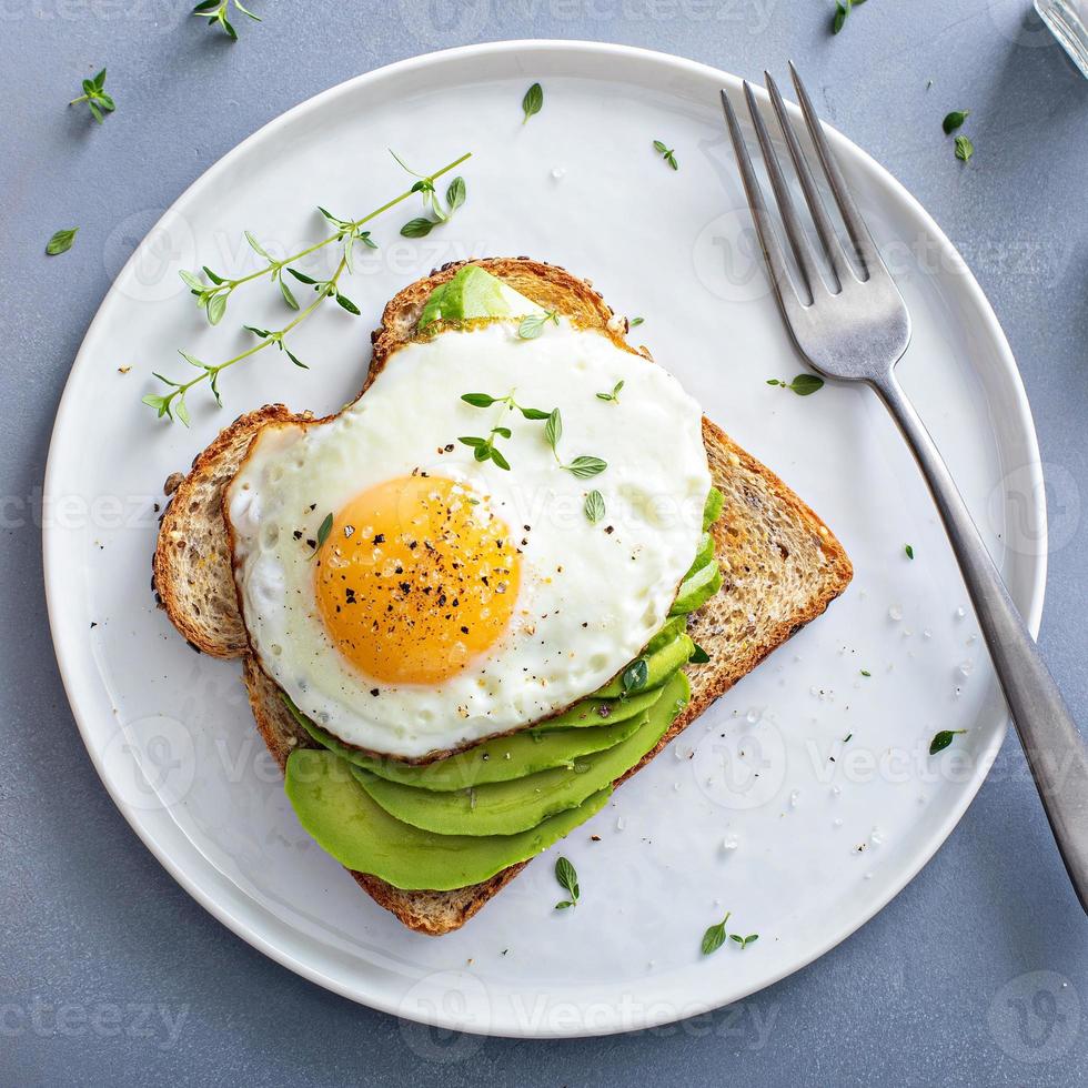 avocado crostini su un' tostato multicereali pane con un' fritte uovo foto