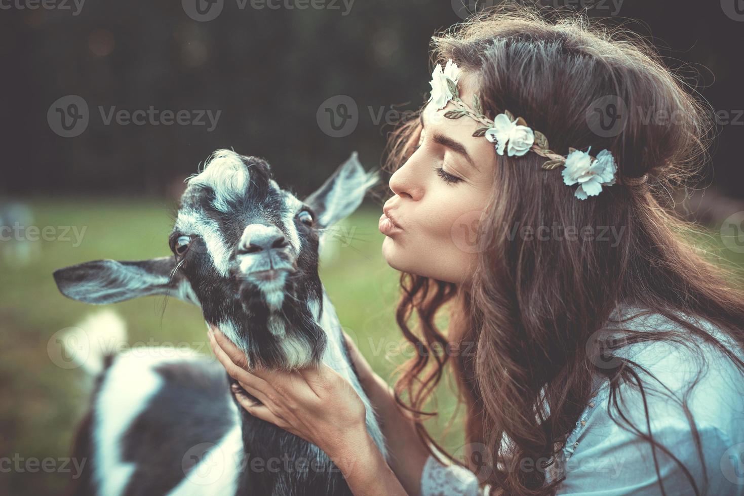 bellissimo donna con un' divertente amichevole capra nel il villaggio foto